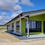 External shot of white and green custom built home