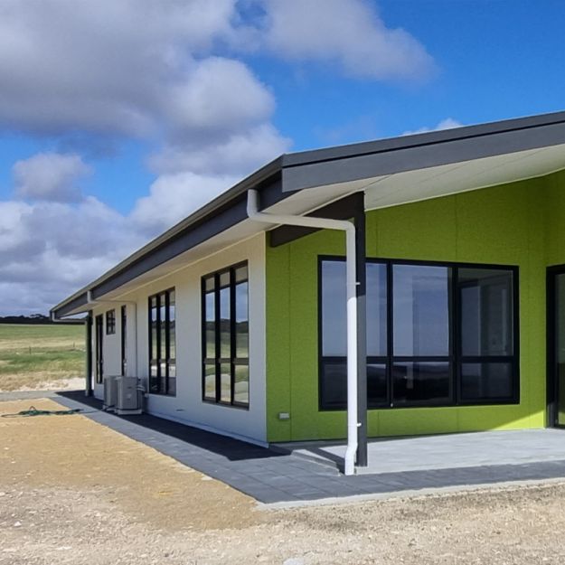 External shot of white and green custom built home