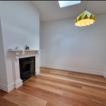 Lounge area with fireplace and solid wooden flooring with skylight