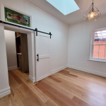 Light and airy living room with sliding door and stained glass window