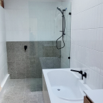 Modern, grey and black bathroom with waterfall shower